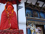 Kathmandu Durbar Square 06 03 Hanuman Statue And Entrance Gate Stone lions flank the sides of the Hanuman Dhoka gate in Kathmandus Durbar Square, one ridden by Shiva, the other by his wife Parvati. Above the gate a brightly painted niche is illustrated with a central figure of a ferocious Tantric version of Krishna. On the left side is the gentler Hindu Krishna in his traditional blue colour accompanied by two of his comely milkmaids. On the right side are King Pratap Malla and his queen.